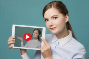 Woman holding a screen of herself on Youtube, monetizing her YouTube videos with captions