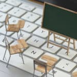 Miniature school furniture on a keyboard to represent e-Learning.