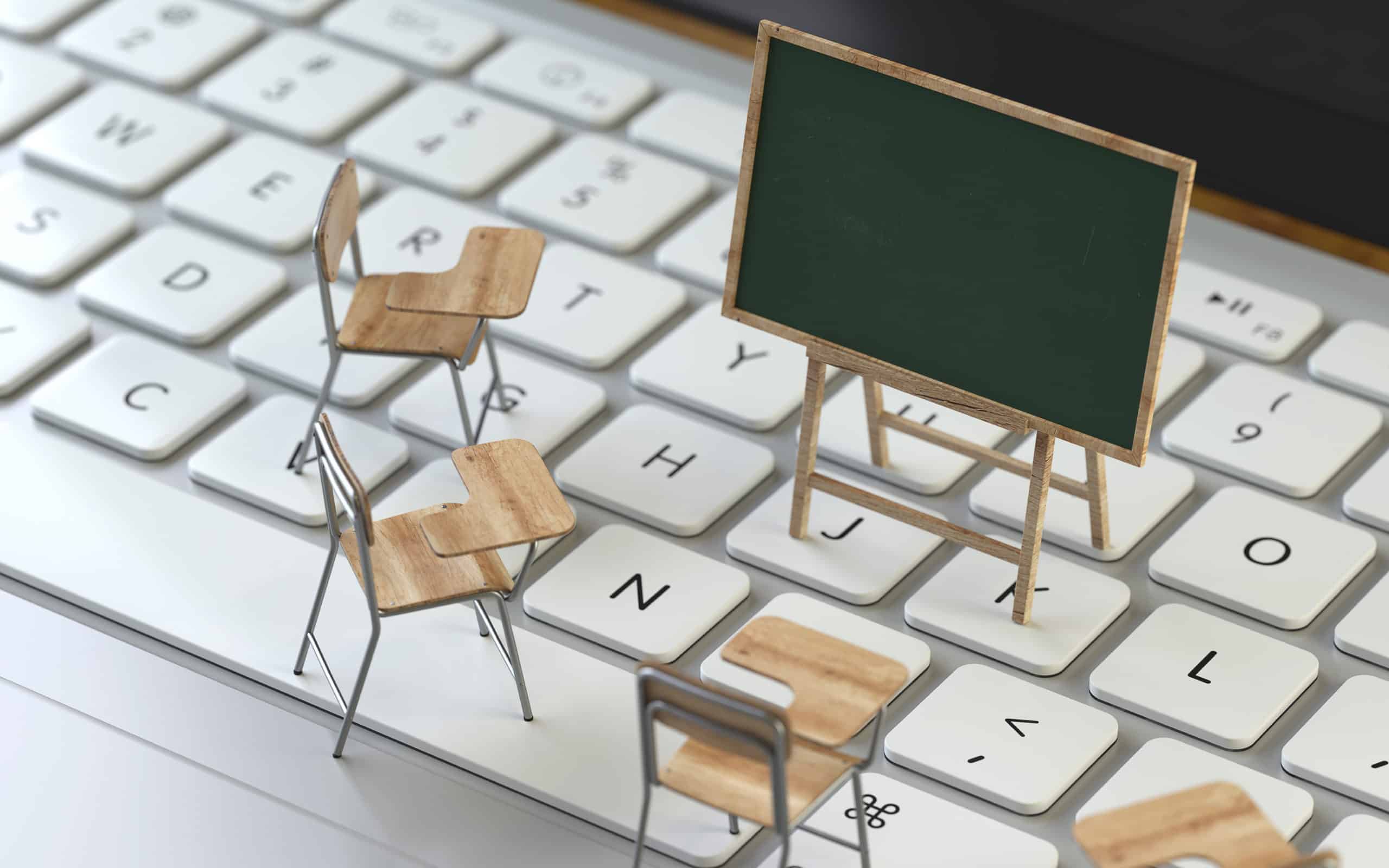 Miniature school furniture on a keyboard to represent e-Learning.