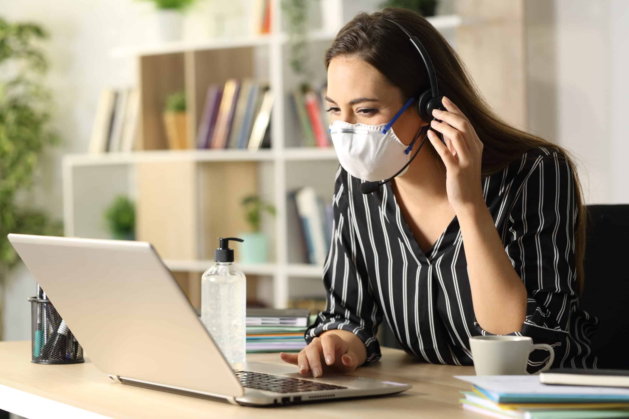 Happy young woman avoiding coronavirus working on her computer with video marketing at homeoffice