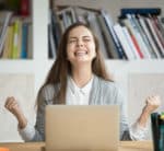 Excited female student feels euphoric celebrating online learning success thanks to video captions in education
