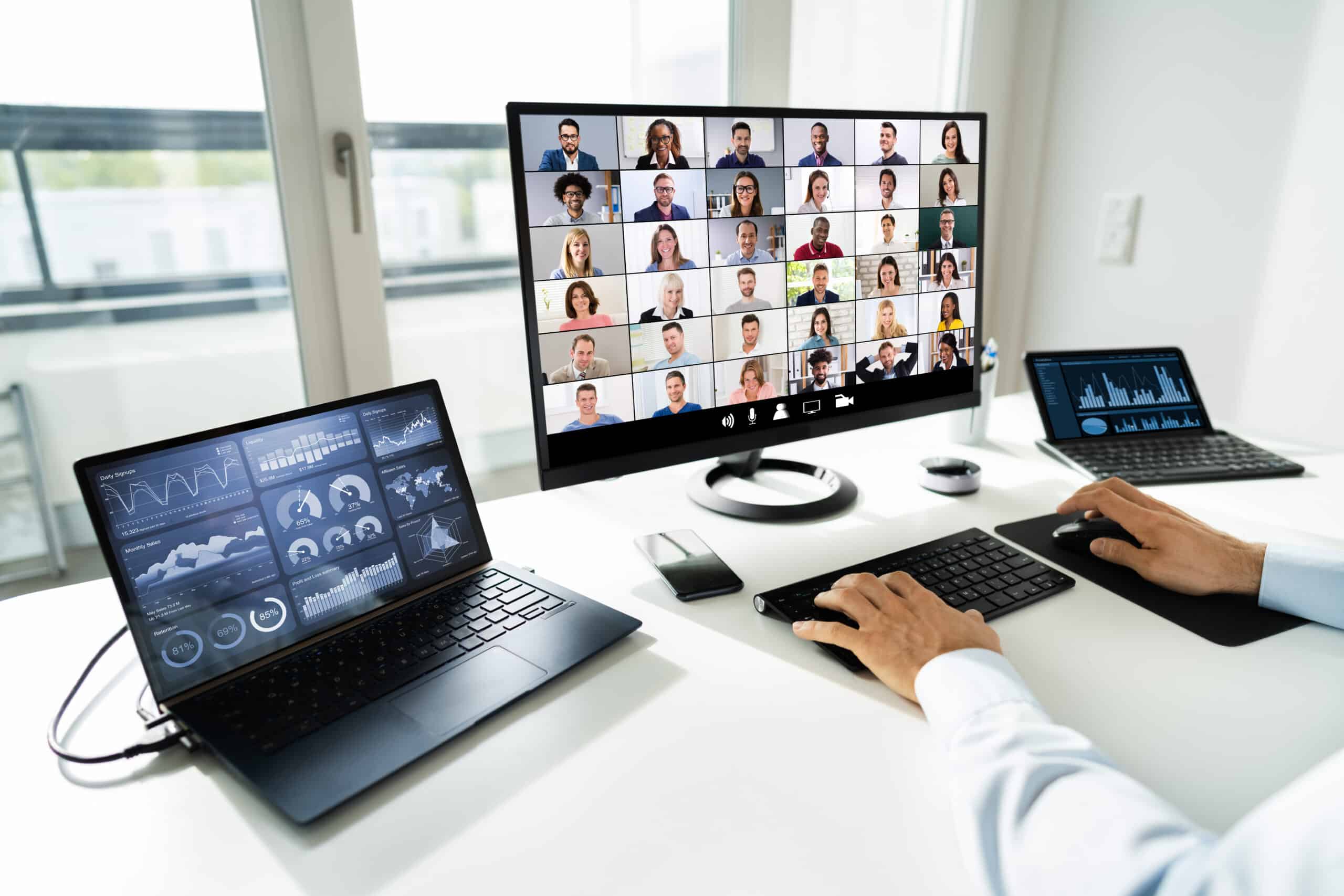 Person sitting at a desk with three computer monitors