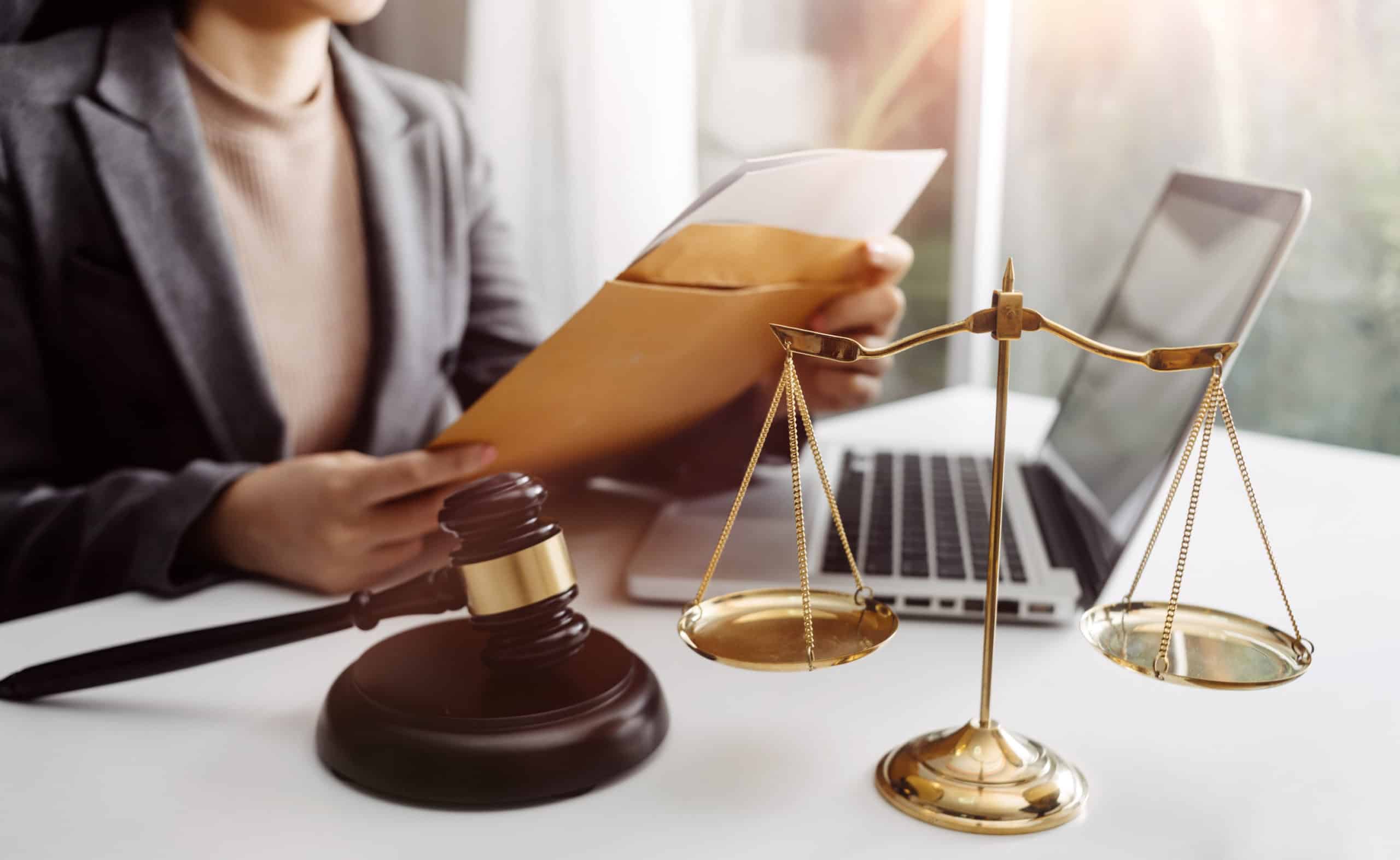 Business and lawyers discussing contract papers with brass scale on desk in office. Law, legal services, advice, justice and law concept picture with film grain effect