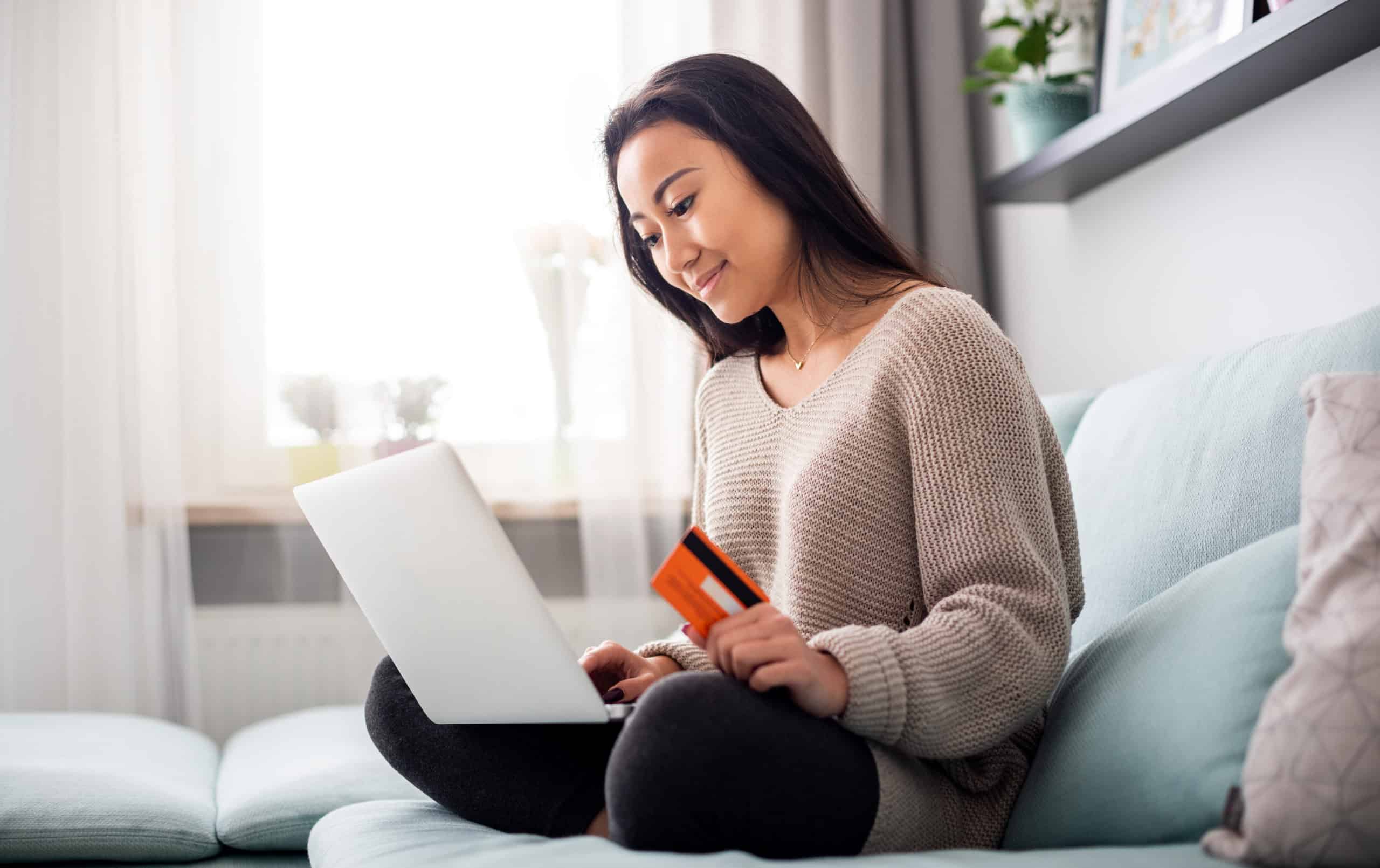 Young girl making online payment using laptop for shopping at home