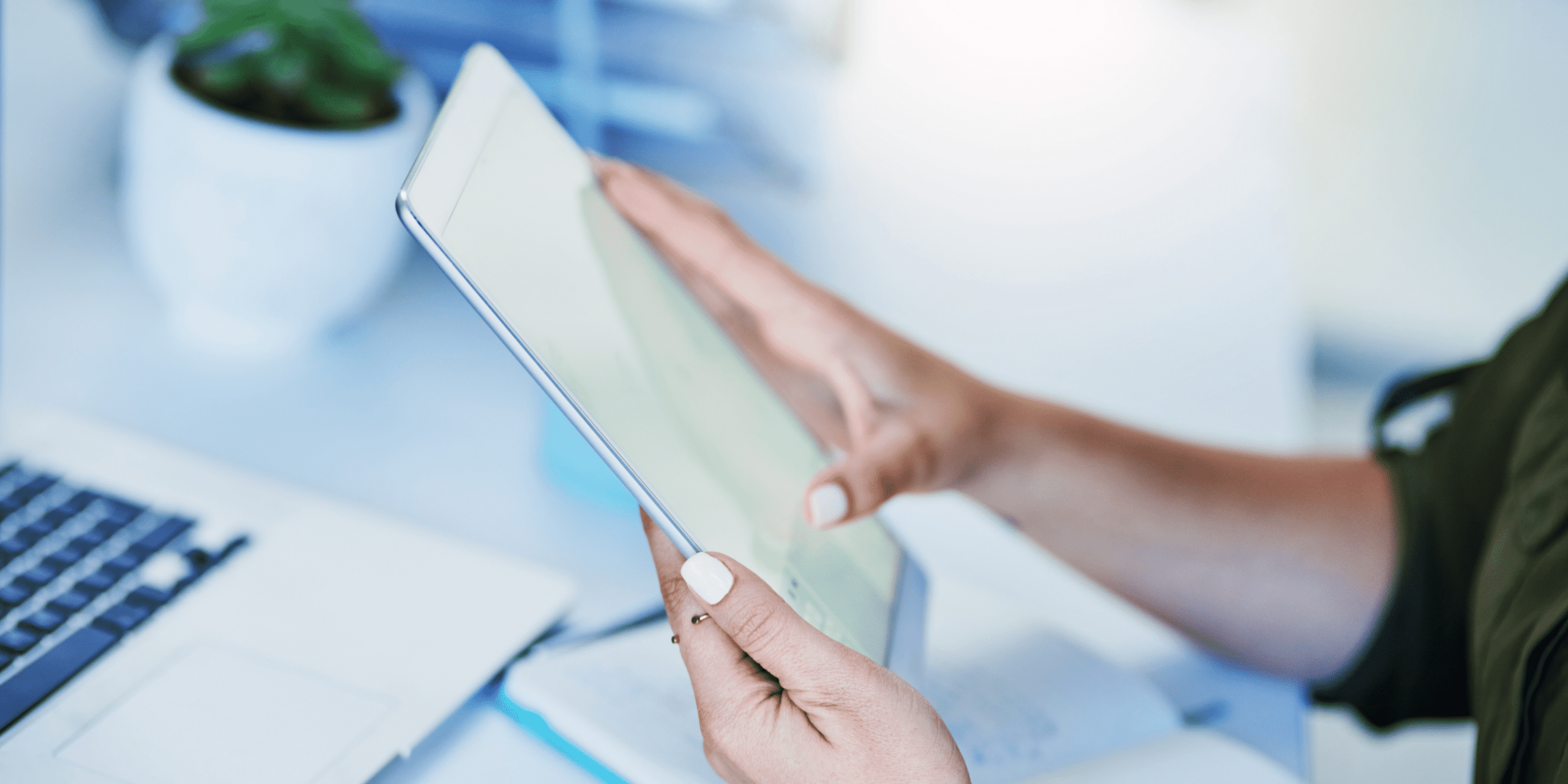 Person using tablet in front of laptop