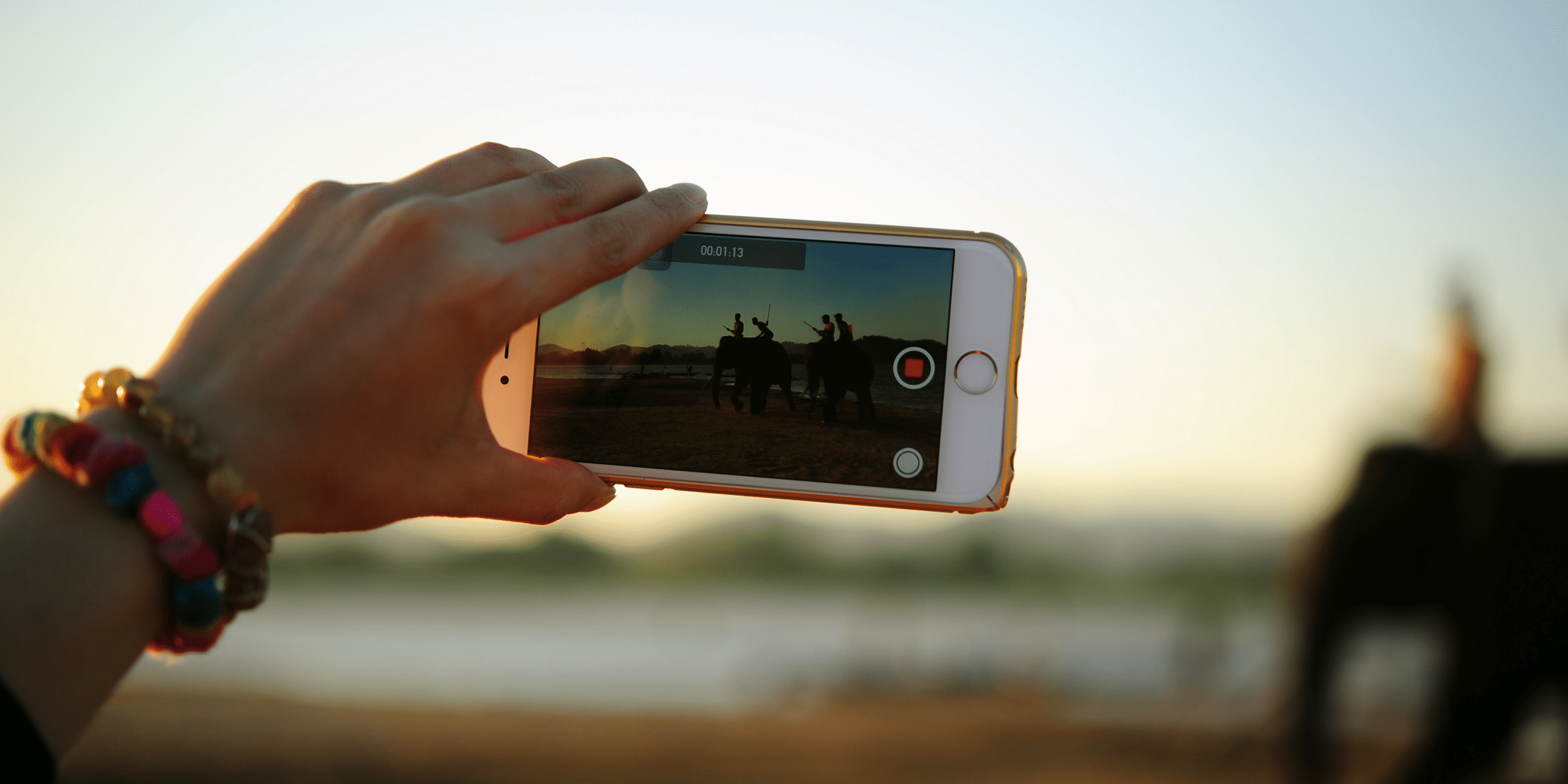 Person filming a sunset on a smartphone