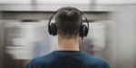 Person wearing headphones looking at a blurry screen